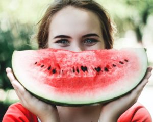 woman holding sliced watermelon